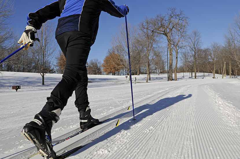 close up of a cross-country skier on a groomed trail.