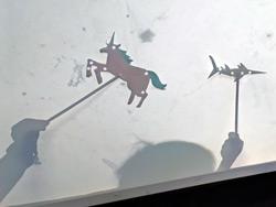 Photo of a unicorn and swordfish shadow puppets.