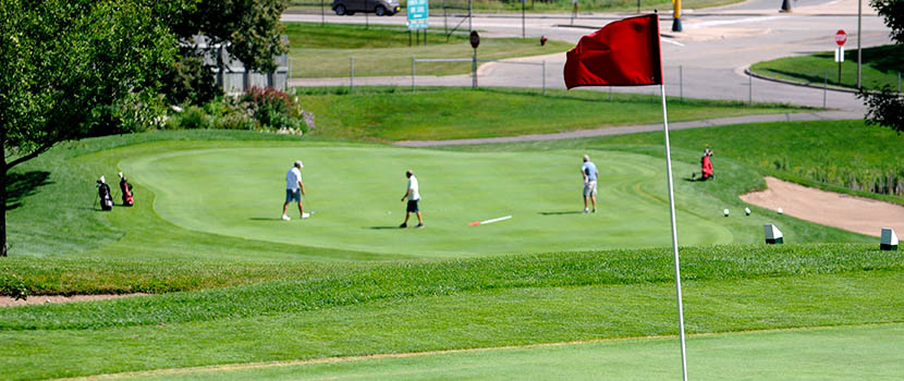 Golf course with men on a putting green