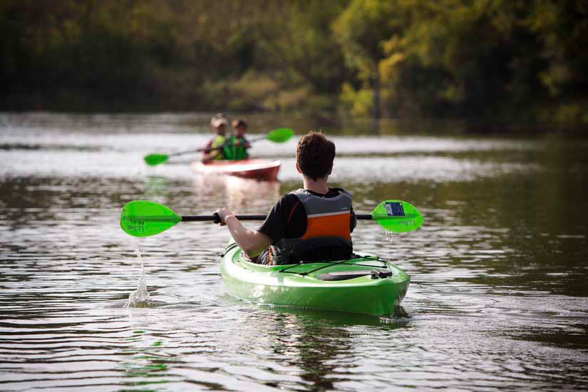 Youth kayaking on lake