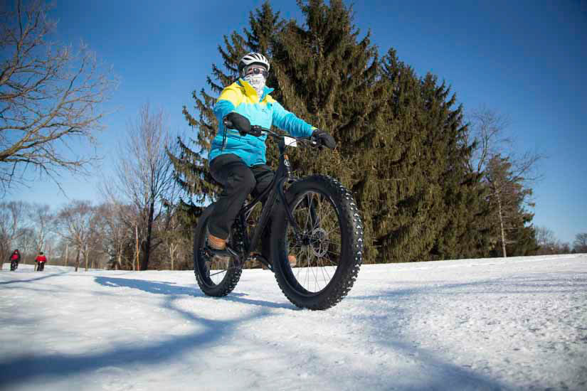 Woman riding fat bike on a snowy trail