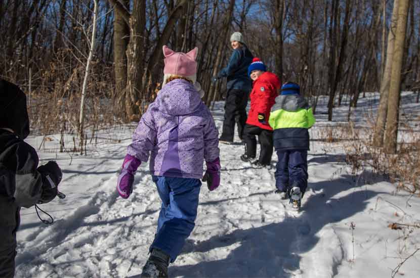 kids walking down a snowy trail.