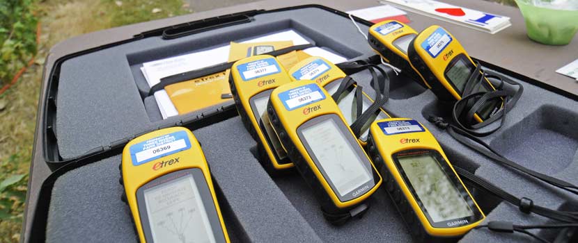 Black and yellow GPS units sit on a table.