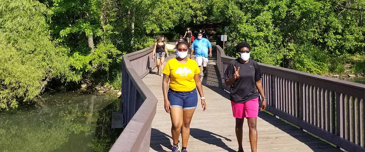 Group of women walking on a wooden boardwalk at Silverwood Park in St. Anthony.