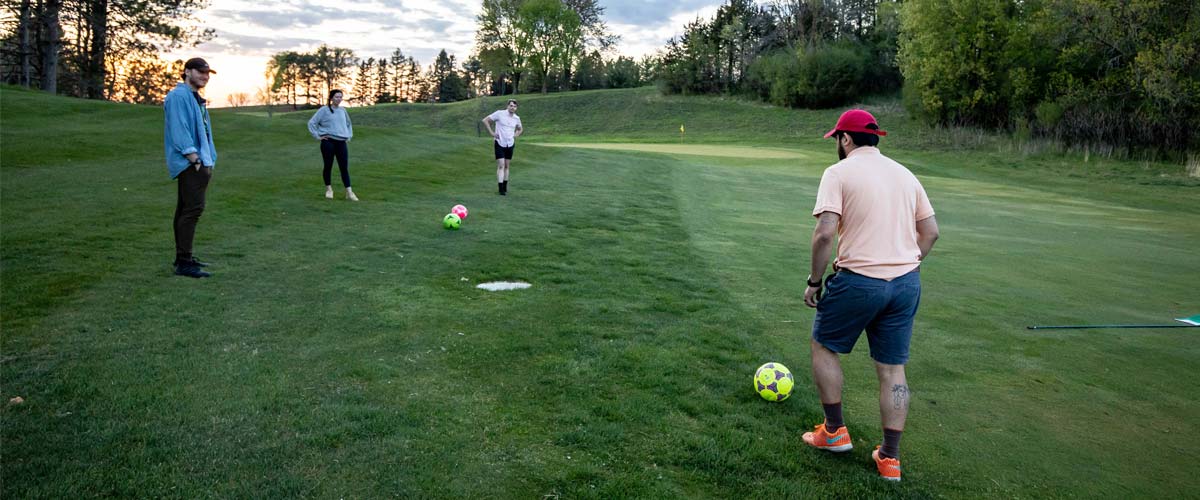 A group of people play footgolf at Baker National.