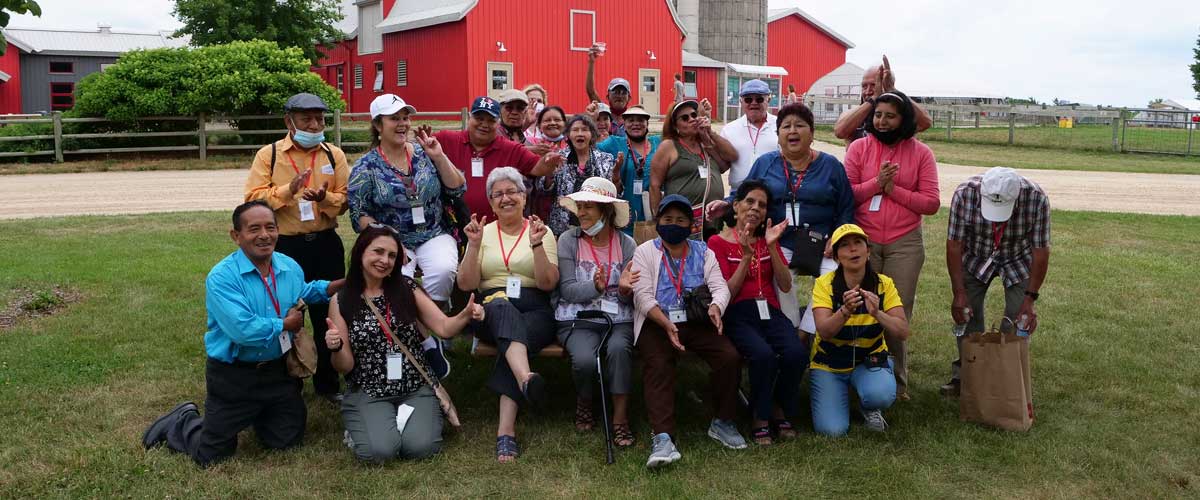 A group from the Three Rivers Latino Seniors initiative take a group photo outside of Gale Woods Farm.