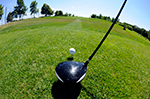 a golf club sits near a golf ball on grass.