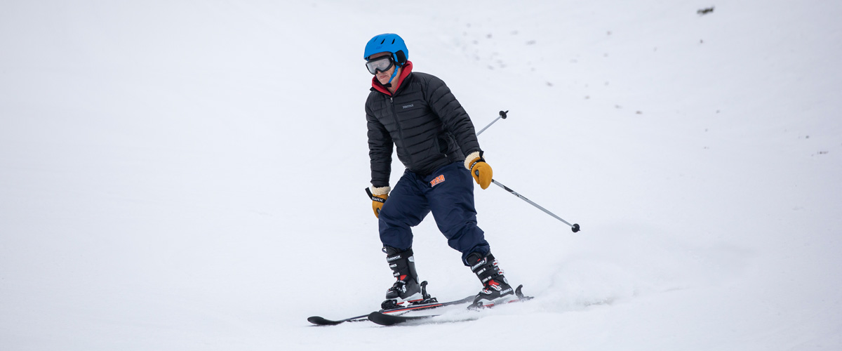 A downhill skier skis down the hill.