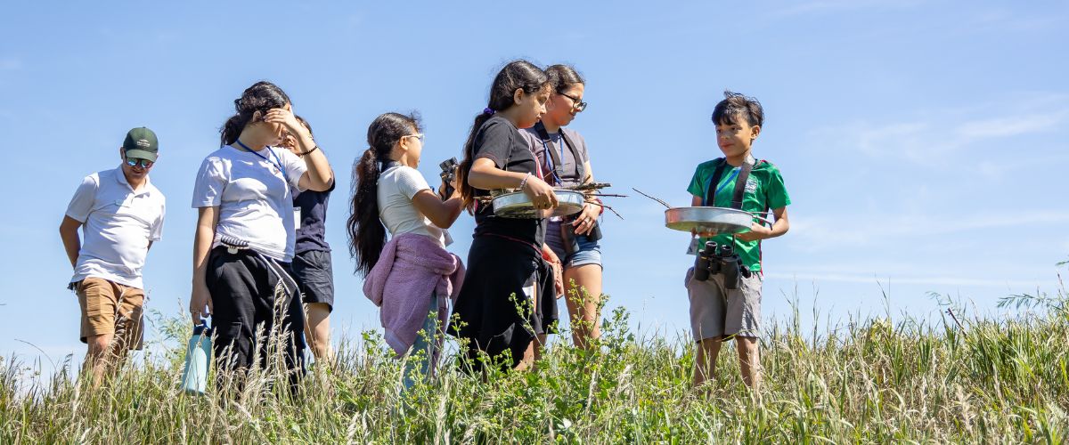 A group of kids walking through a prairie during a summer camp