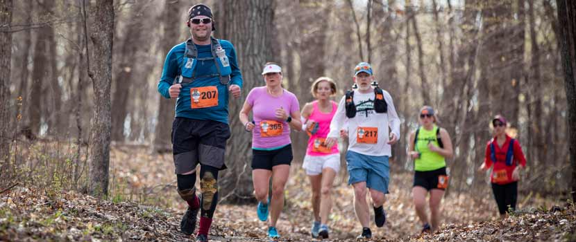 A group of runners run through the woods at Trail Mix in 2021.