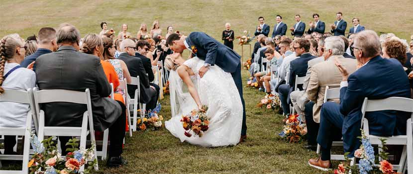 A groom kisses his bride at a ceremony at Hyland Hills.