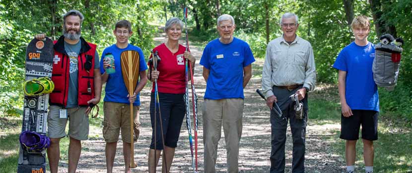 The 2021 Distinguished Volunteers stand on a wooded trail.