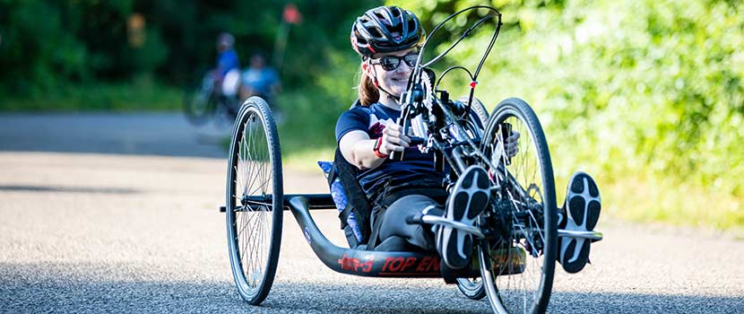 A person takes an adapted bike out on the trail.