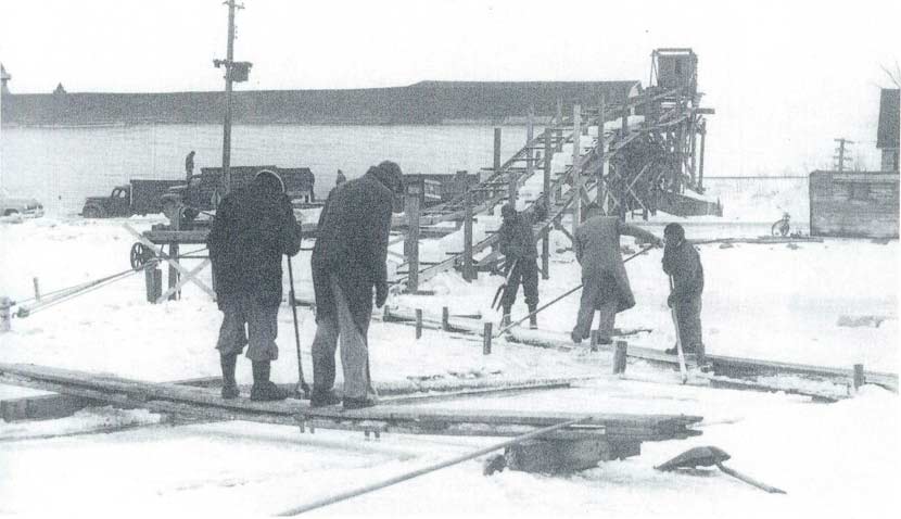 historic image of ice harvesters loading and filling an ice house on Lake Okabena
