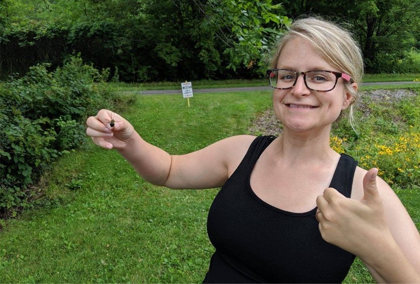 Wildlife biologist Angela Grill holds up a rusty patched bumble bee.