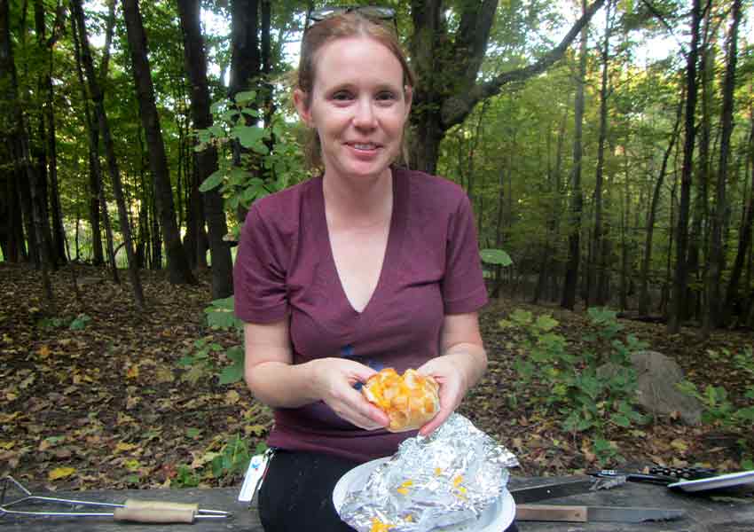 woman holding food from a foil packet