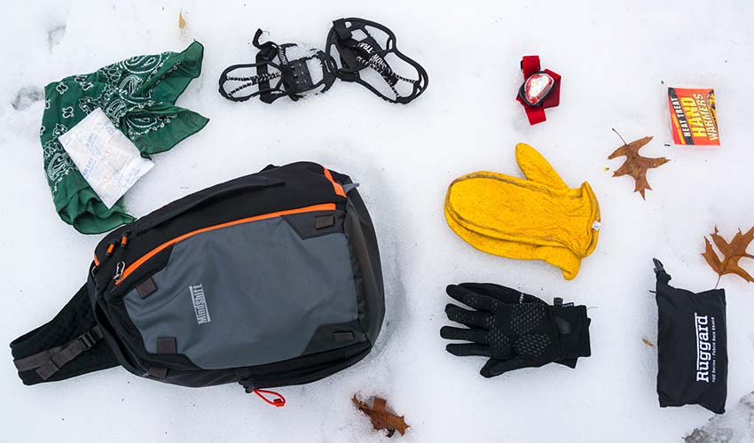 gloves, backpack and camera equipment laying in snow