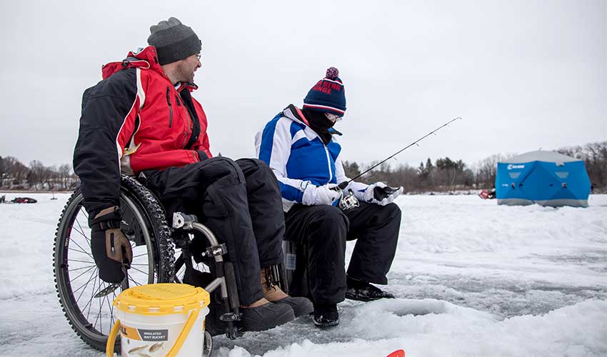two people ice fishing on a lake