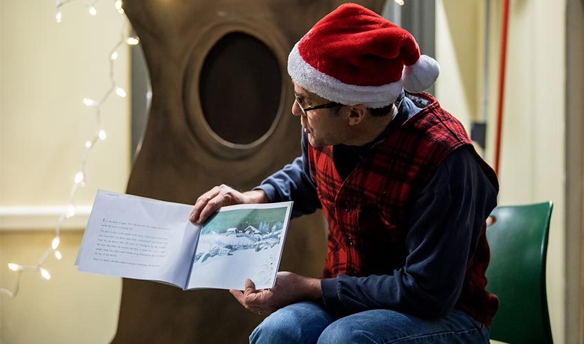 tim wearing a santa hat reading Tomten